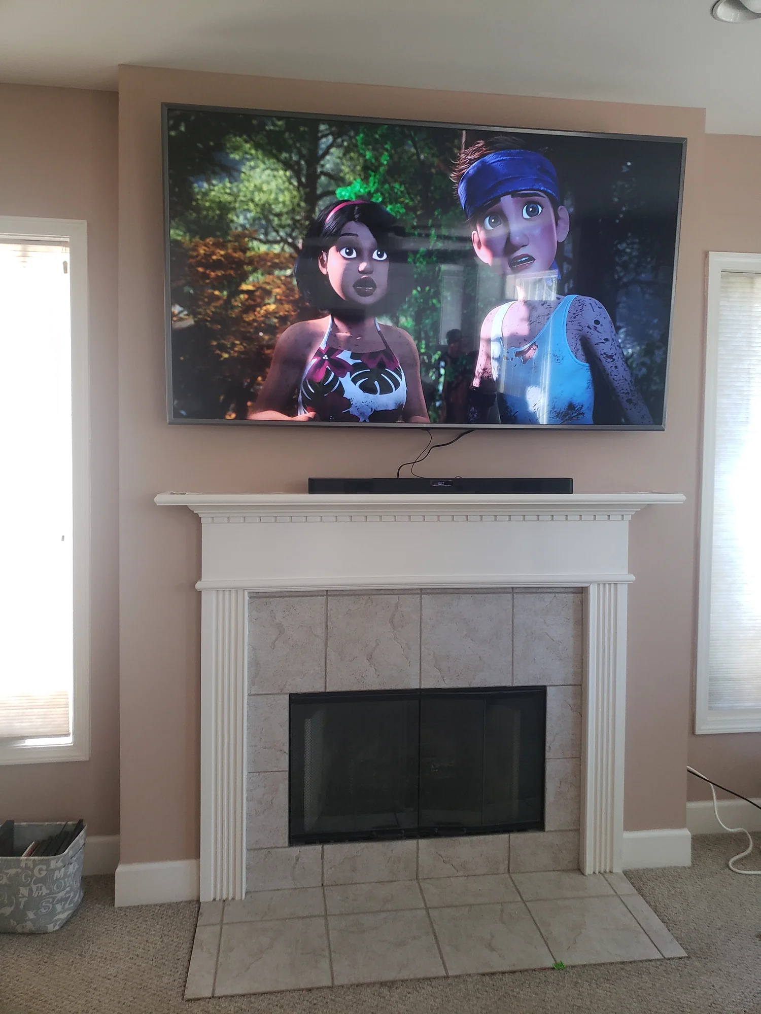 Television displaying an animated scene above a white fireplace surround.