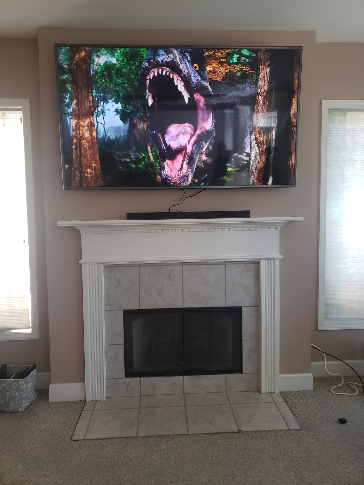 Wall-mounted television above a white mantel and tiled fireplace.